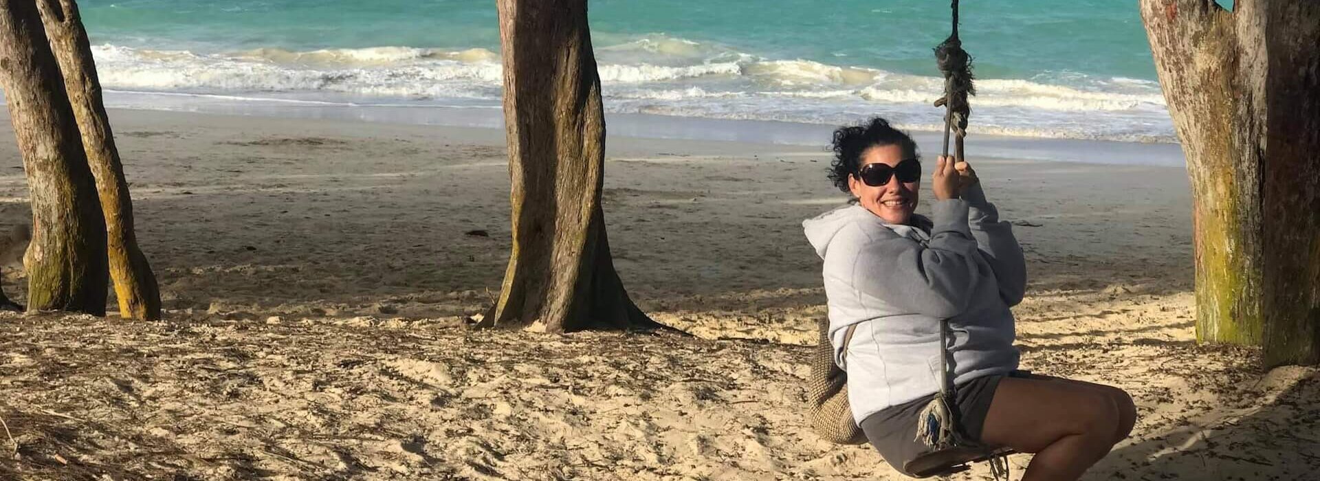 Travel agent on a swing at Kailua Beach, Hawaii, on Oahu